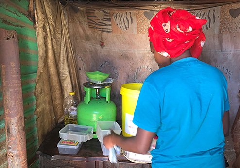 Woman cooking in a settlement in Soweto, South Africa 