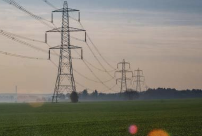 Electricity towers over a green field
