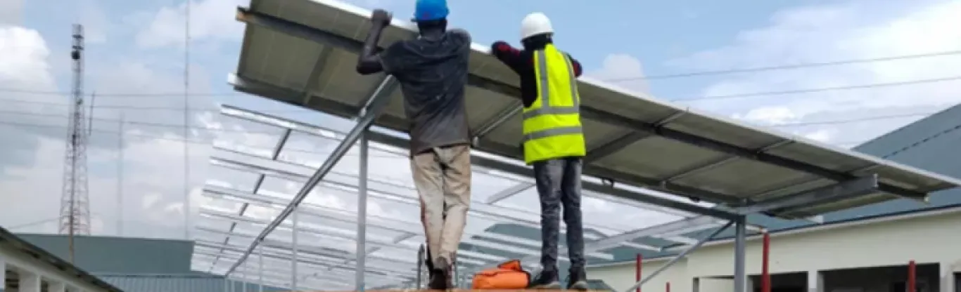 workers install a solar array at a large hospital in Nigeria.