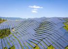 Aerial shot of mountain slopes covered with photovoltaic panels