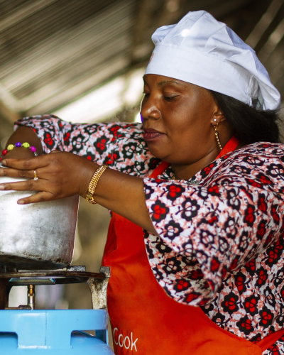 Person cooking a meal on a gas stove in a household kitchen.