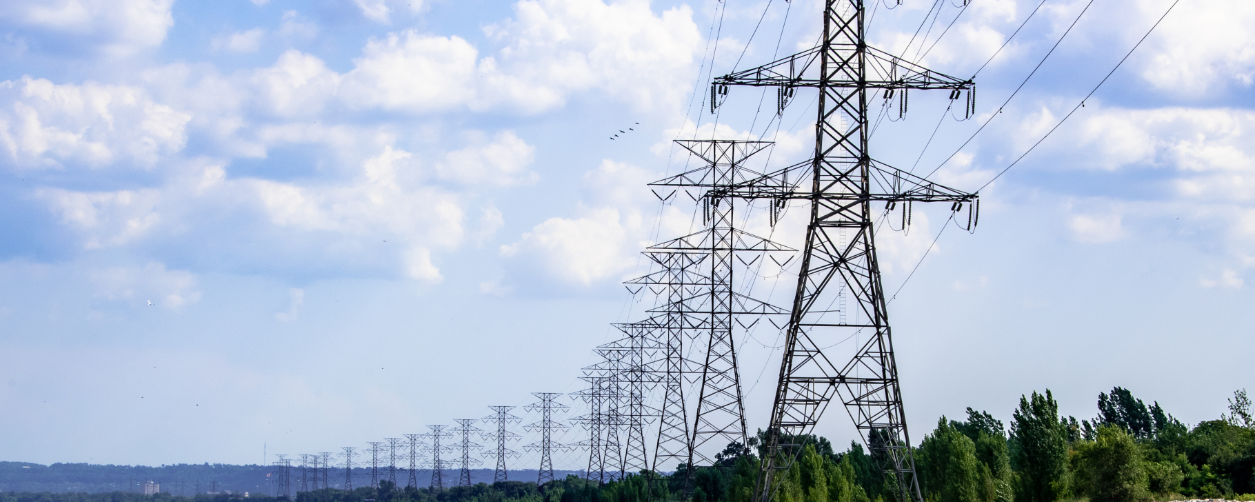 Tall metal electricity towers spanning across a wide body of water