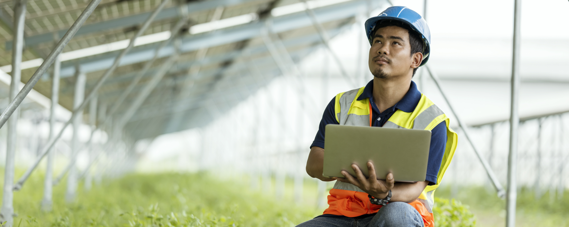 Person uses a laptop computer under a solar panels