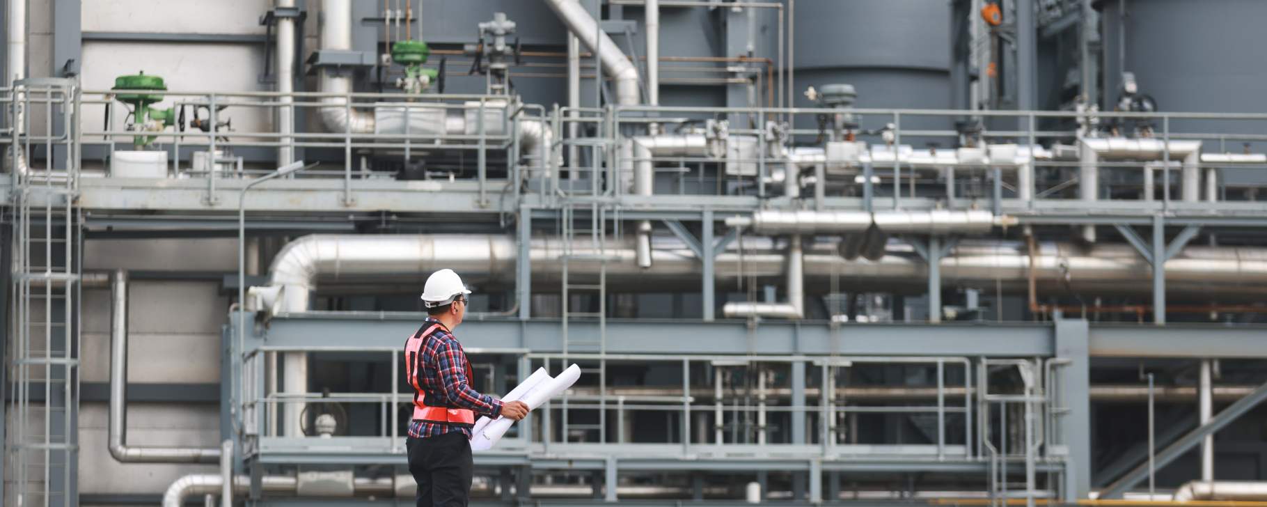 Energy worker standing in front of an industrial plant