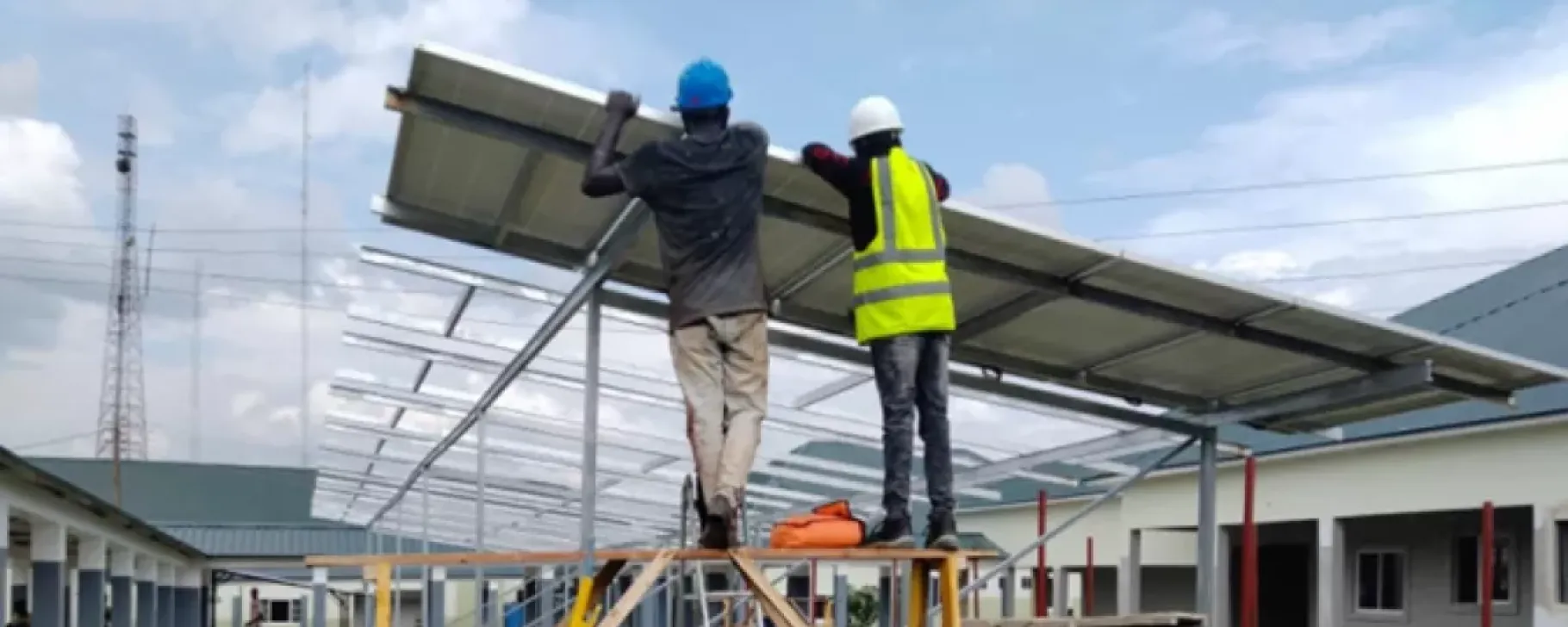 workers install a solar array at a large hospital in Nigeria.