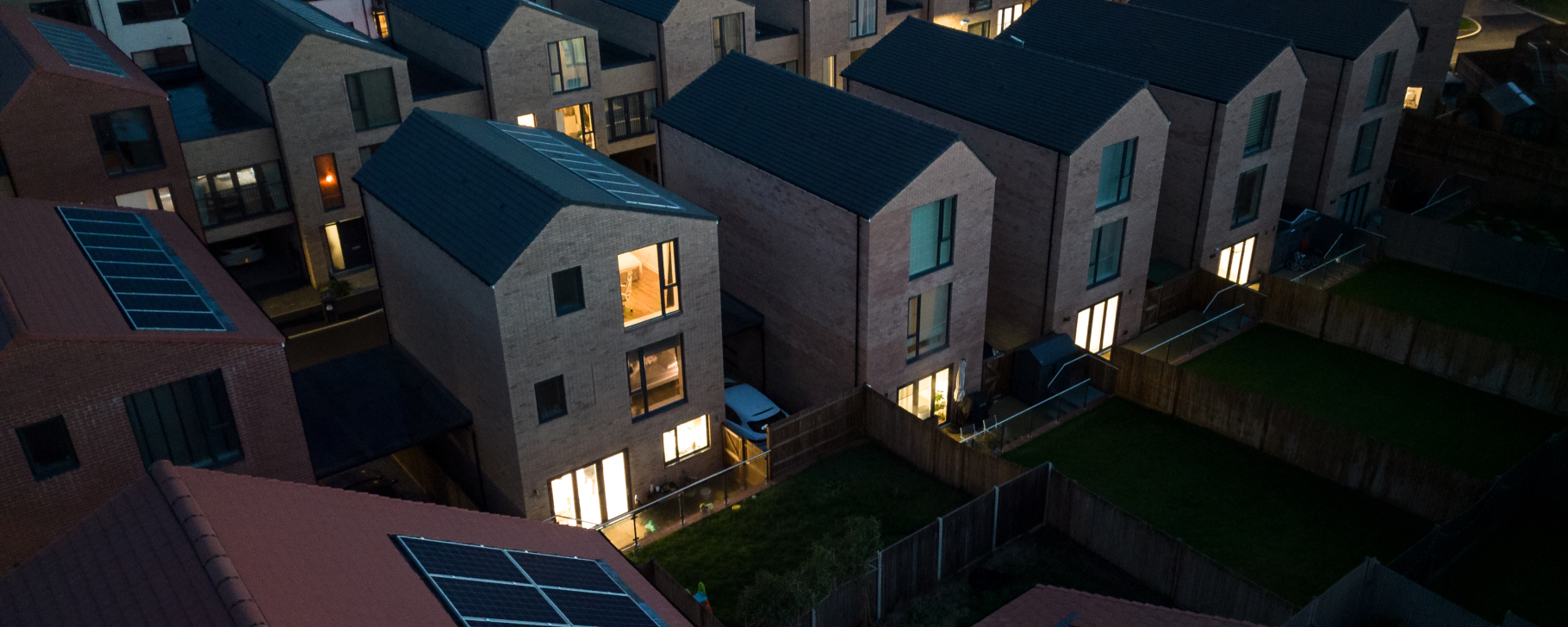 Aerial view of homes with solar panels installed on the rooftops at dusk