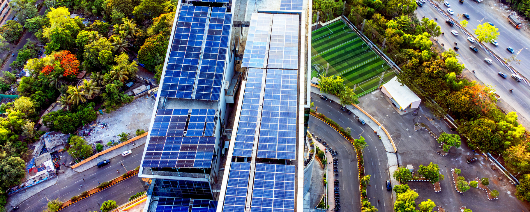 Aerial view of a modern green building featuring rooftop solar panels and sustainable urban infrastructure