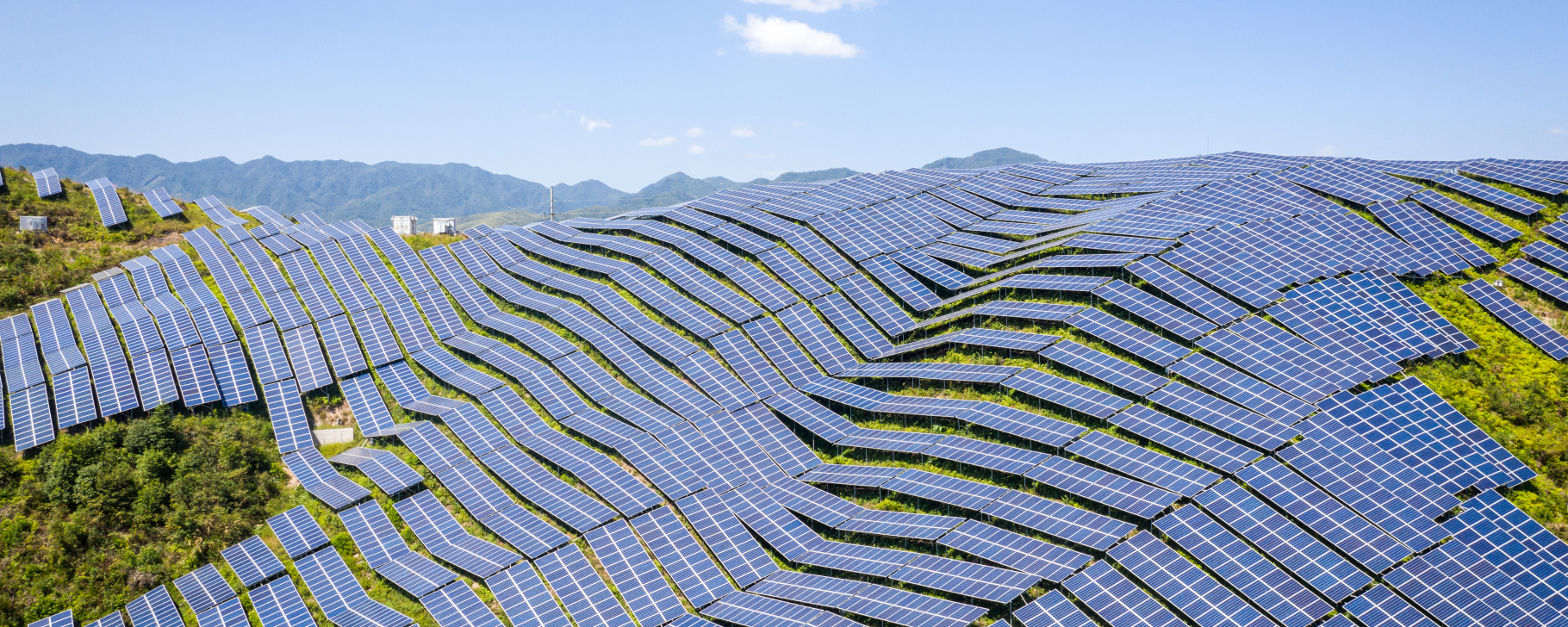 Aerial shot of a mountain slope covered with photovoltaic panels
