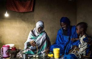 Rockefeller Foundation's initial contribution of up to $50 million to the World Bank’s Energy Sector Management Assistance Program (ESMAP) Two African women and a young child sharing a meal under the light of a solar lamp