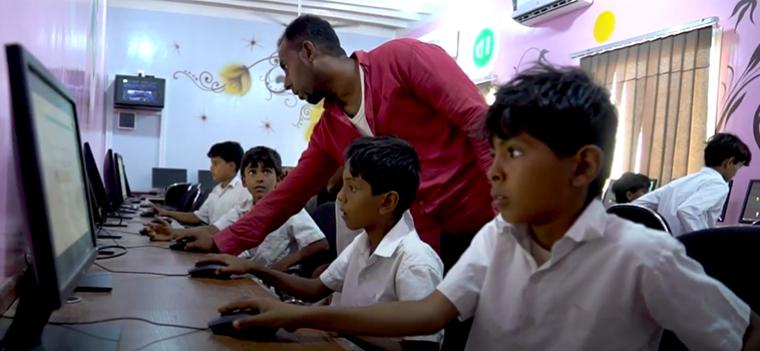 children working on computers in a school in Yemen
