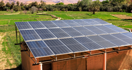 Off-grid Solar Banner - Credit: Getty Images / mariamontoyart Solar panels mounted on the roof of a small building in a rural setting, with trees and open land visible around the structure.