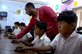 children working on computers in a school in Yemen