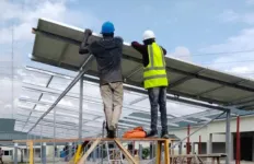 workers install a solar array at a large hospital in Nigeria.