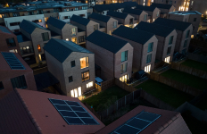 Aerial view of homes with solar panels installed on the rooftops at dusk