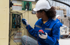 Electrician worker checking operation electric system on circuit board in factory