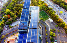 Aerial view of a modern green building featuring rooftop solar panels and sustainable urban infrastructure