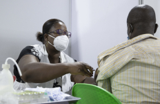 Nurse vaccinating man, Africa